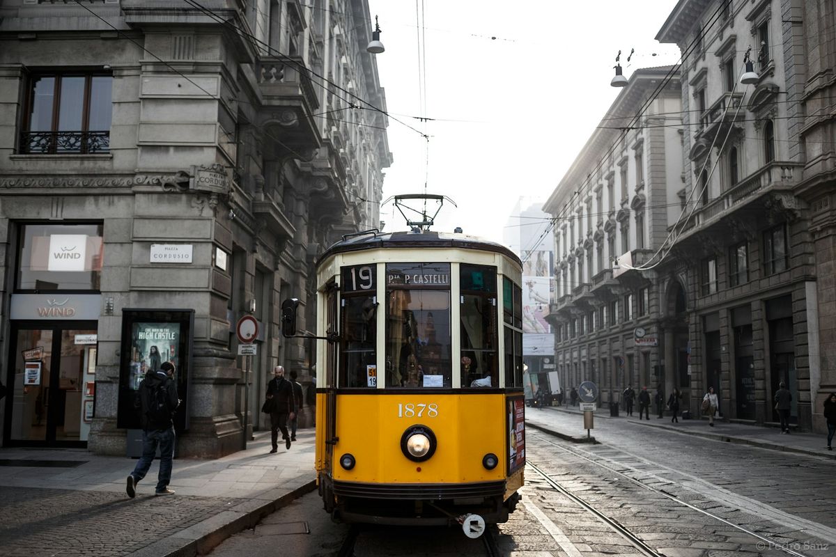 A classic yellow tram on a street in Milan