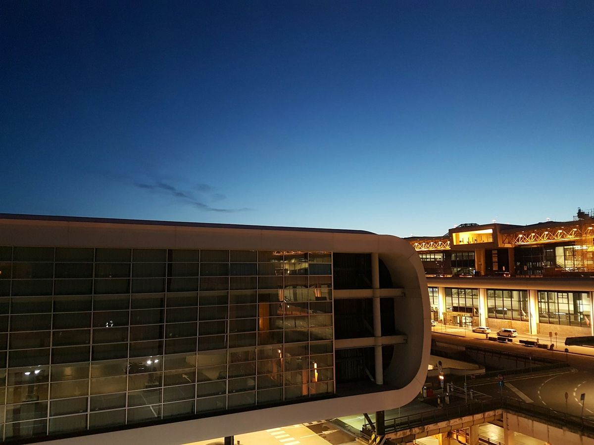 Malpensa Airport Terminal 1 curved facade illuminated at dusk
