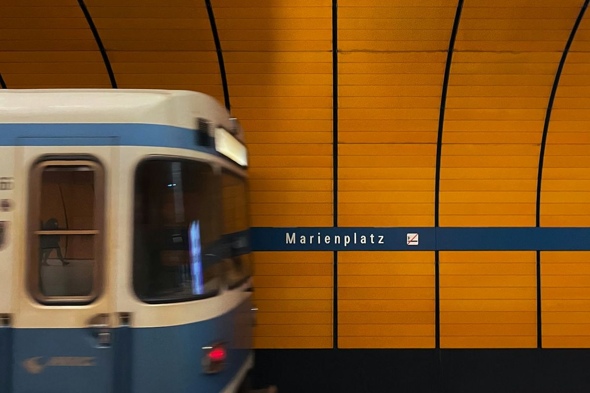 Blue and white Munich U-Bahn train traveling through tunnel