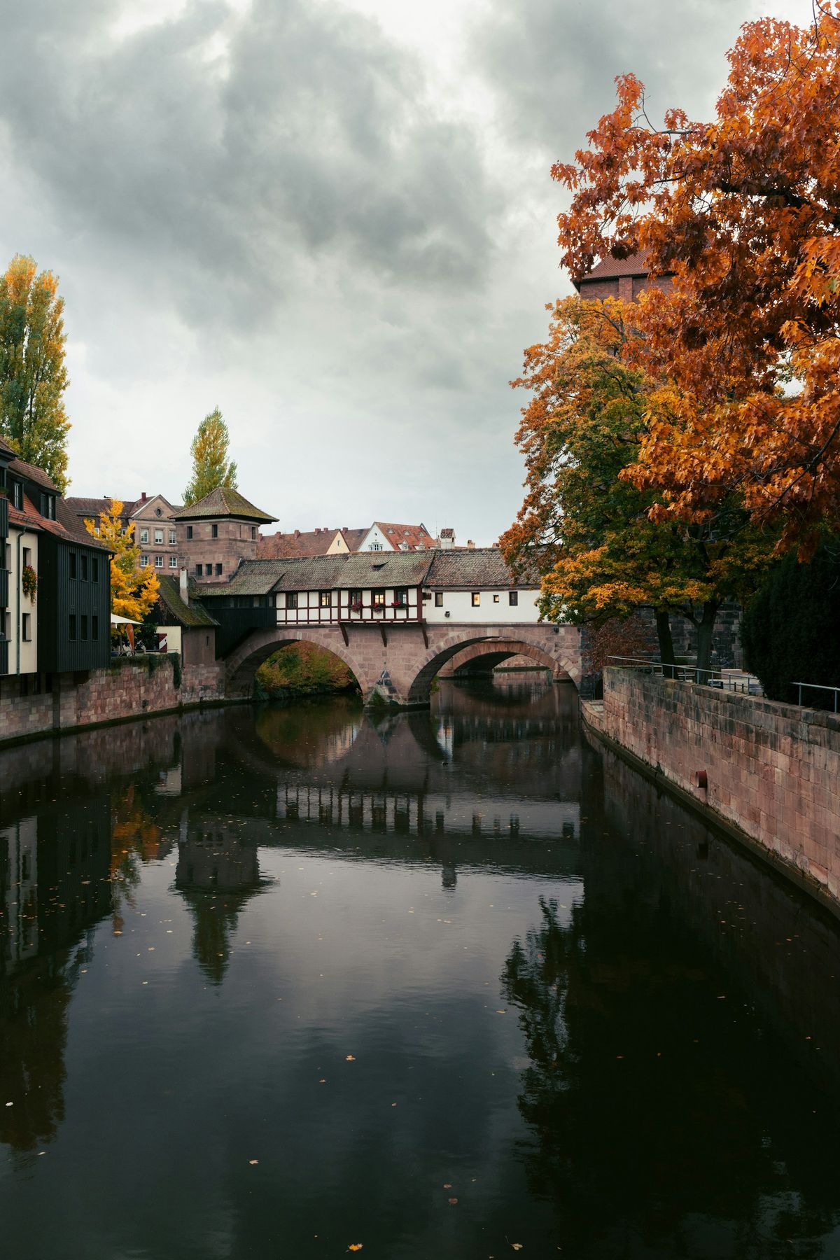 Old bridge over the Pegnitz river in Nuremberg with autumn trees