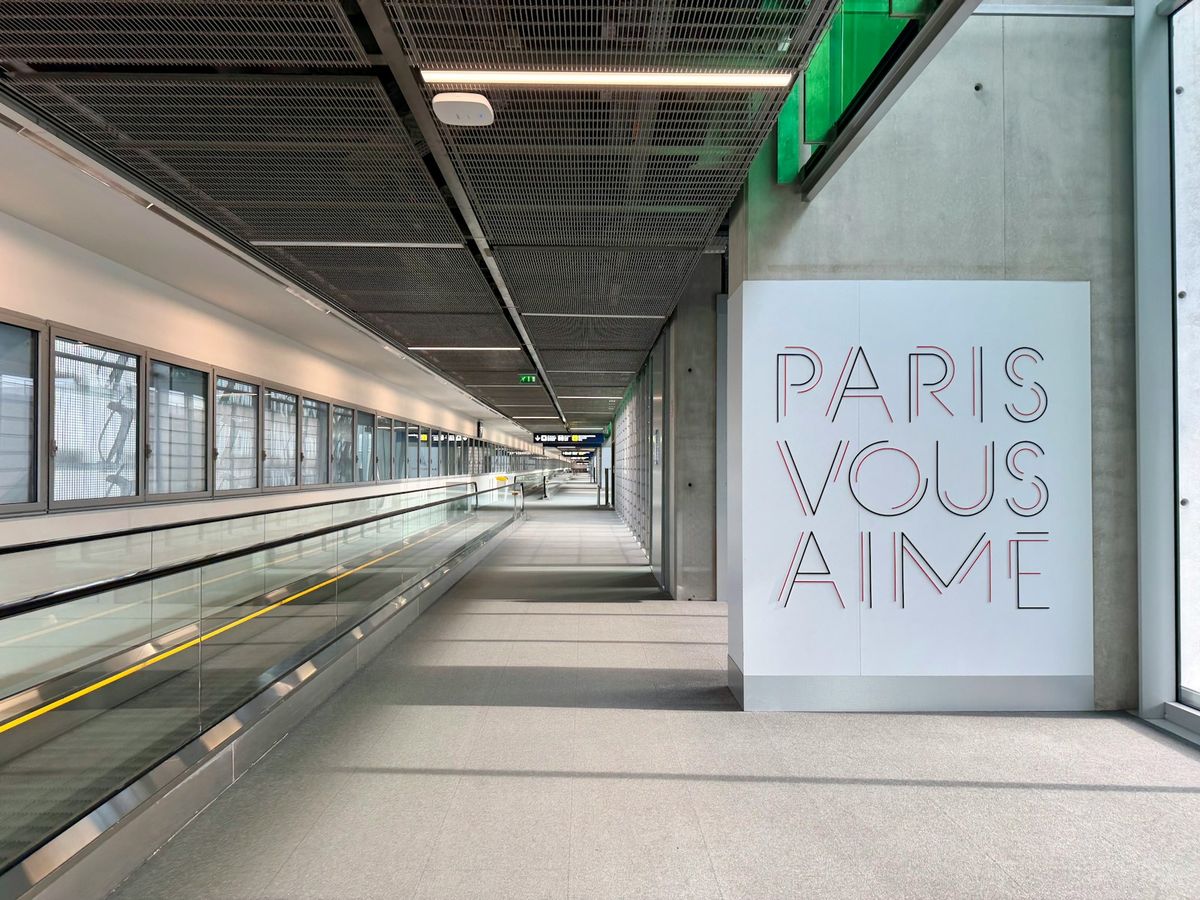 Modern walkway at Paris Charles de Gaulle airport with Paris vous aime art