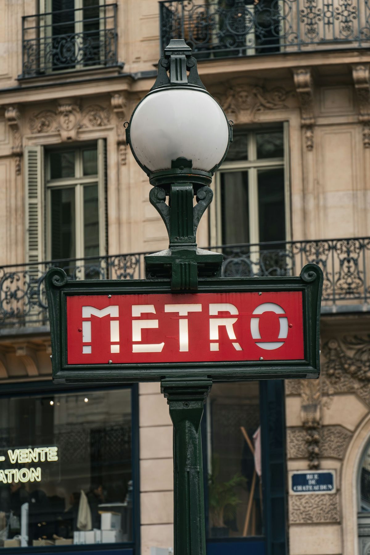 Paris metro sign with ornate Haussmann building backdrop