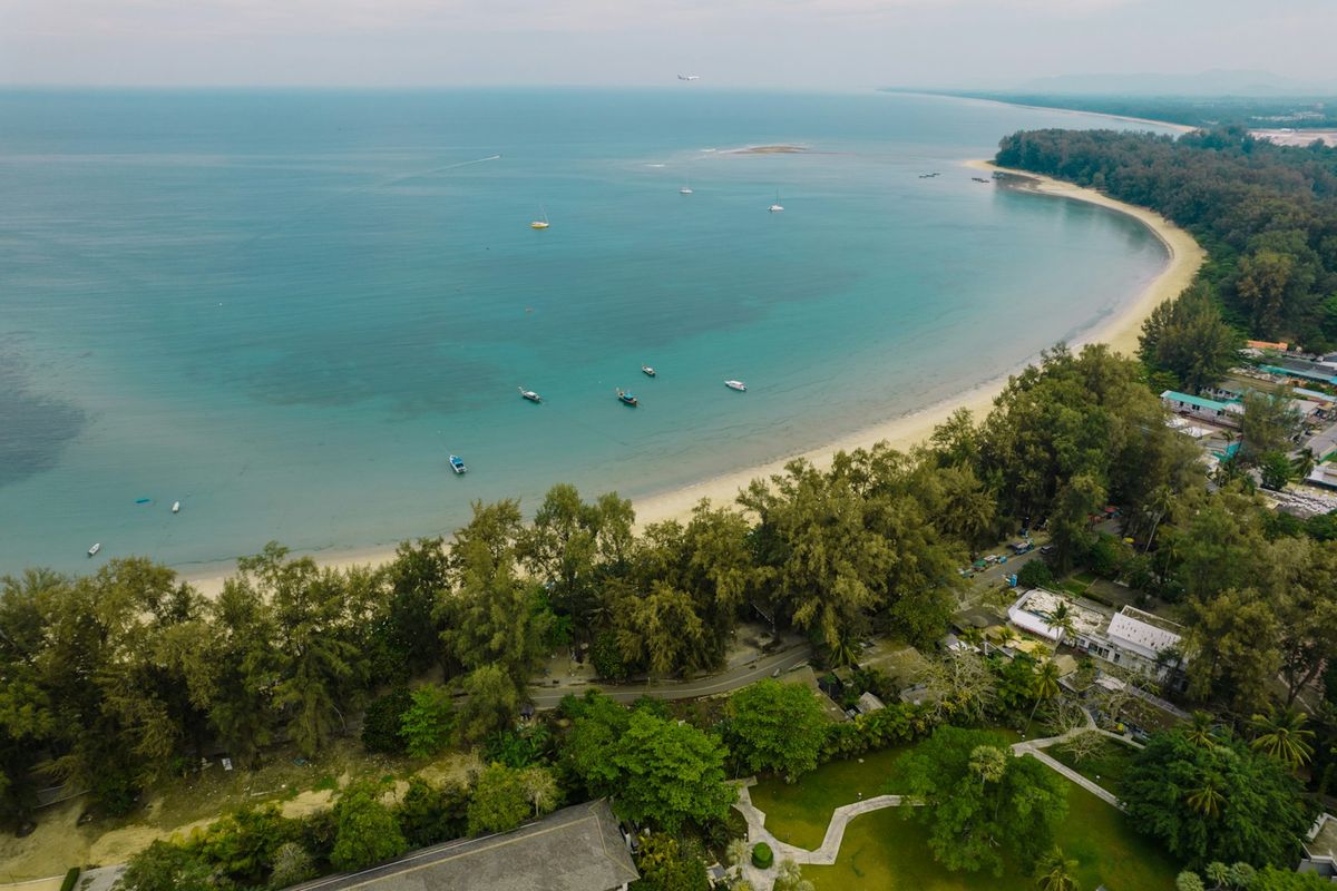 Aerial bird's eye view of a beach and turquoise ocean in Phuket, Thailand
