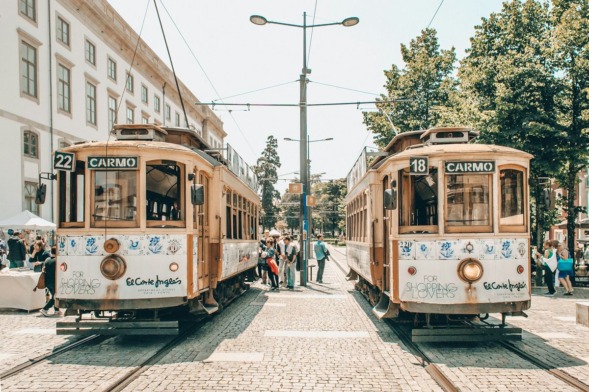 People walking beside Porto tram on city street