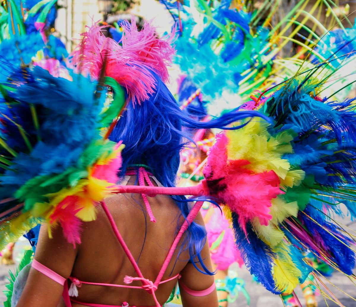 Dancer in a vivid blue and pink feathered headdress at Rio Carnival