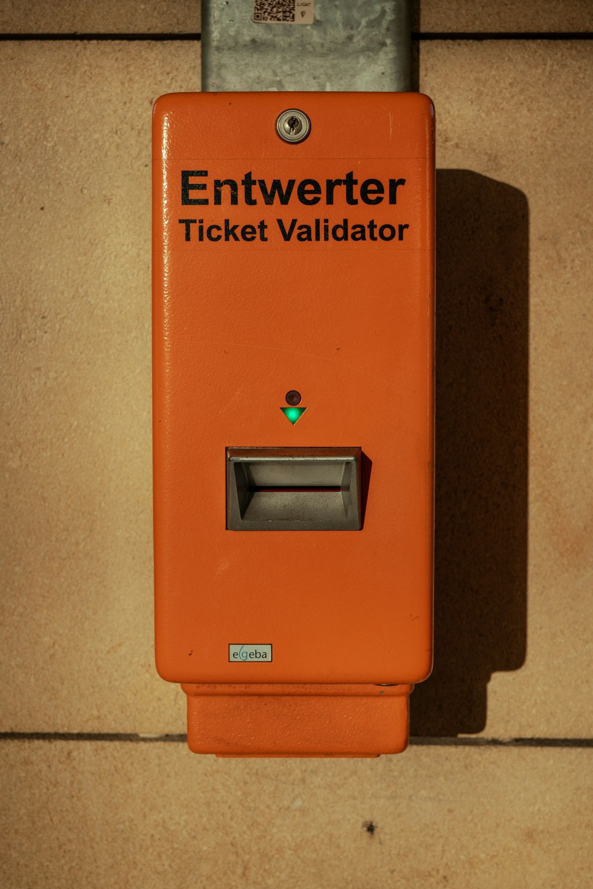 Orange ticket validator machine with green light on a bus