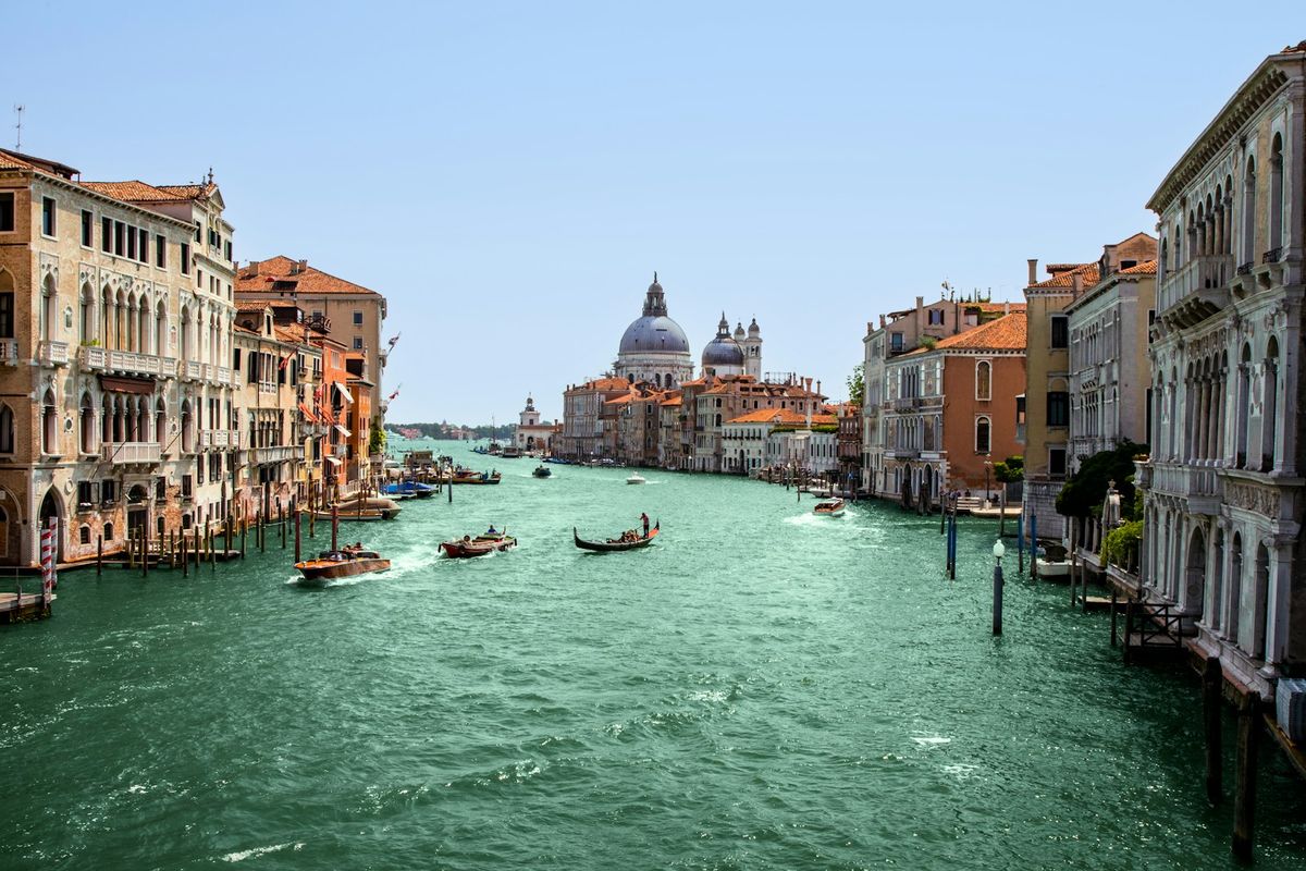 Venice canal with gondolas in the distance