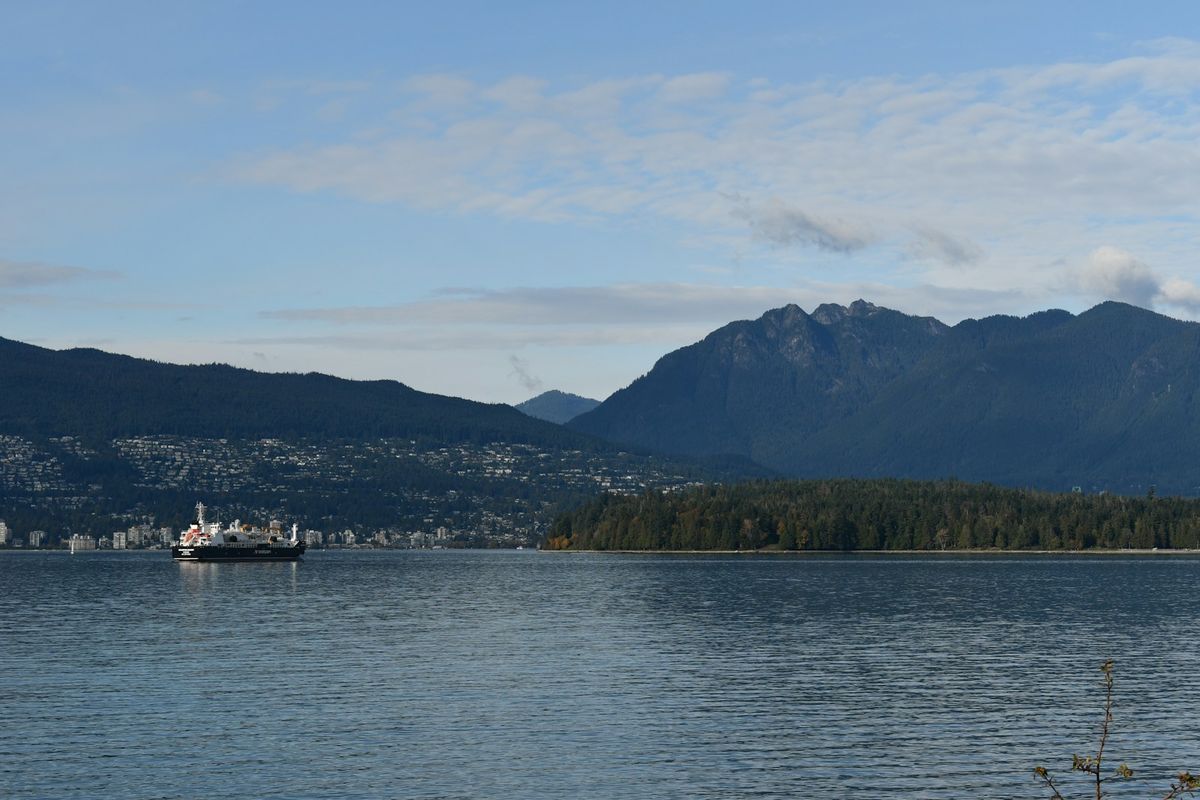 A BC Ferries boat on the water with mountains in the background