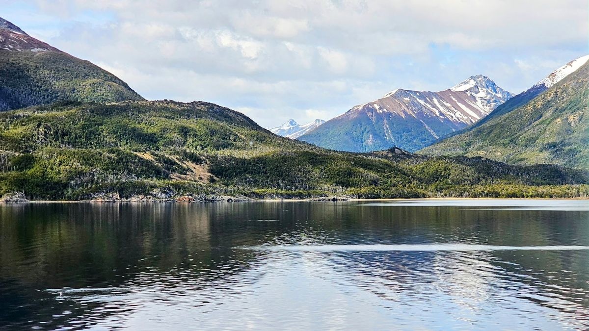Ferry crossing a calm fjord surrounded by mountains in Chilean Patagonia