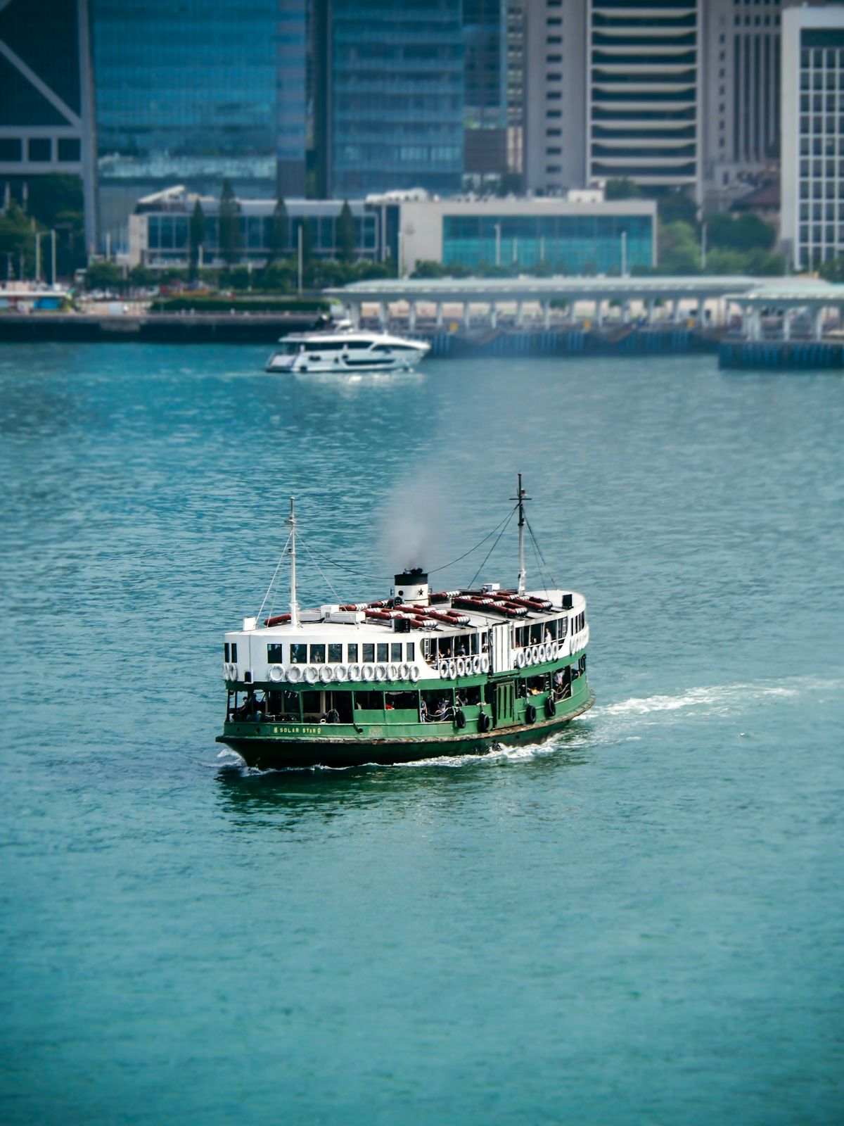 Green and white Star Ferry crossing Victoria Harbour, Hong Kong