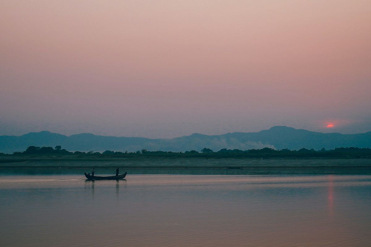 Wooden boat on the Irrawaddy river at sunset, Myanmar