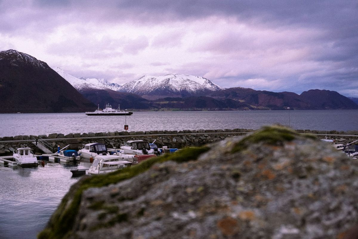 A Norwegian car ferry crossing a fjord with mountains behind