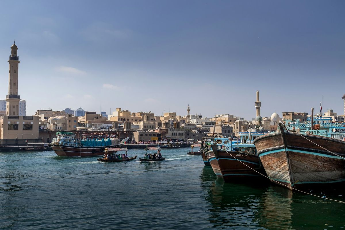 Traditional wooden dhow boats clustered on the water in the Persian Gulf