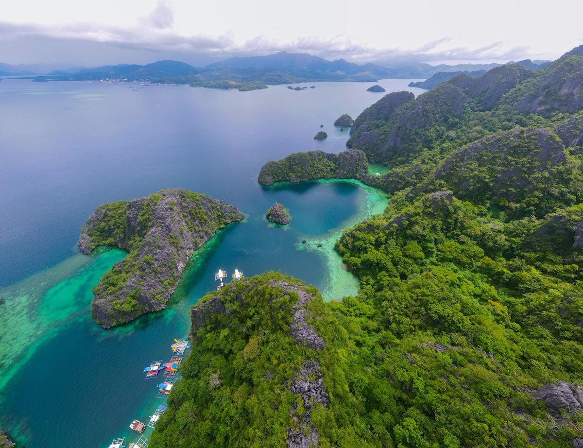Lush green tropical islands surrounded by turquoise waters and boats Philippines