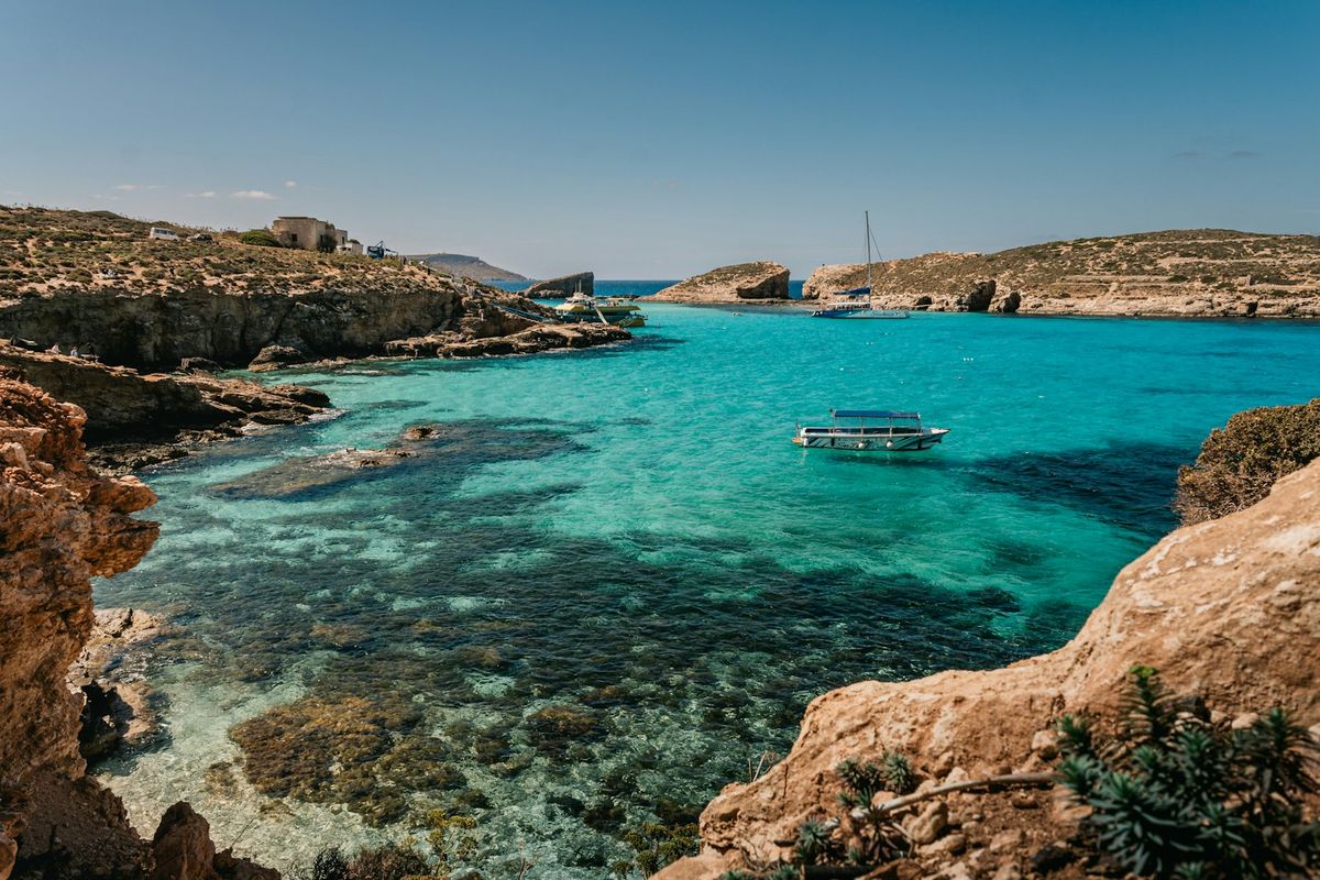 Crystal-clear blue water and boats near Comino, Malta
