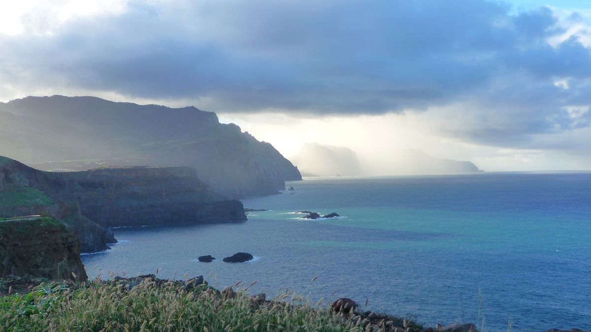 Coastal view of Madeira with hills and cloudy sky over the sea