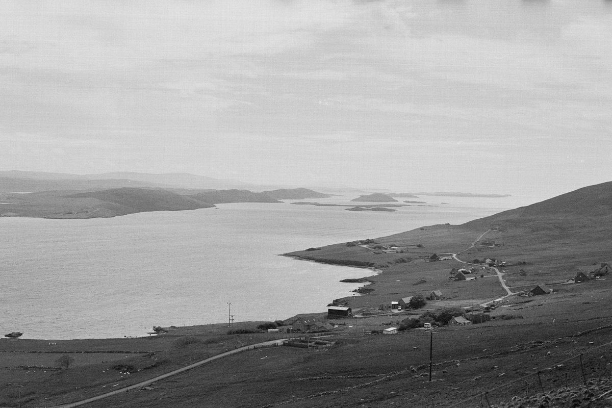 Coastal village on grassy hillside overlooking the Shetland sea