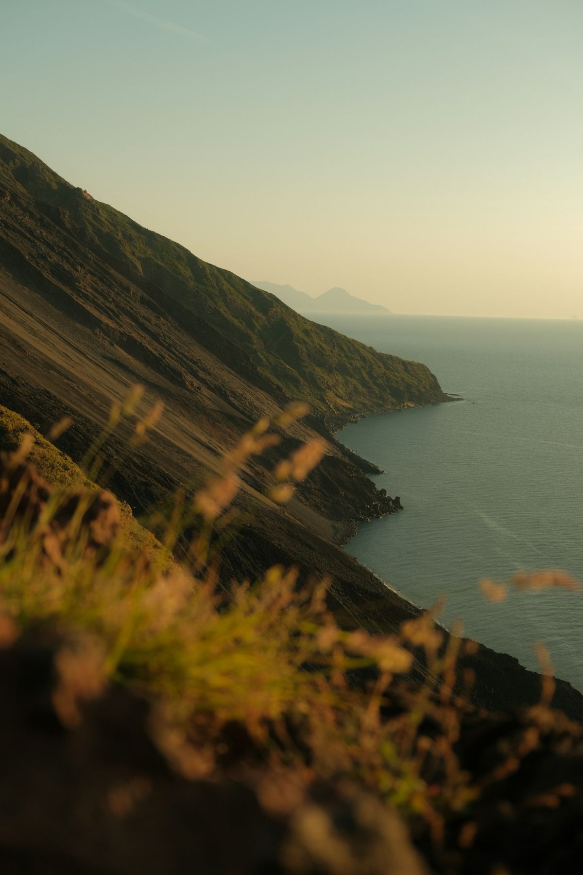 Volcanic mountains of the Aeolian Islands meeting the sea at sunset