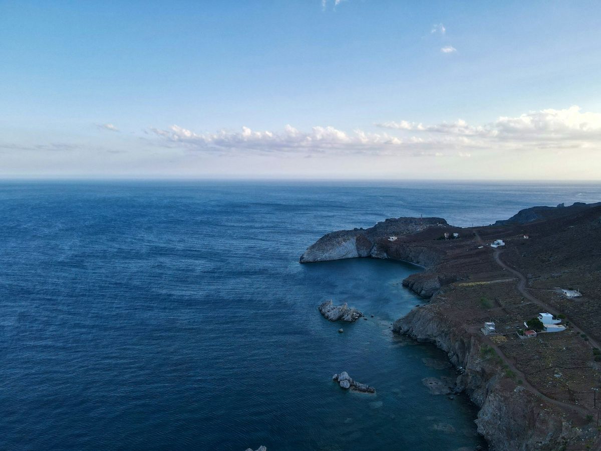 Aerial view of a Greek island coast with turquoise sea and buildings