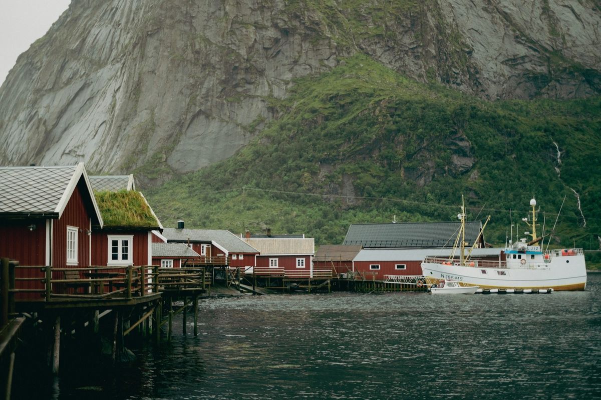 Boat docked in front of dramatic Lofoten mountains