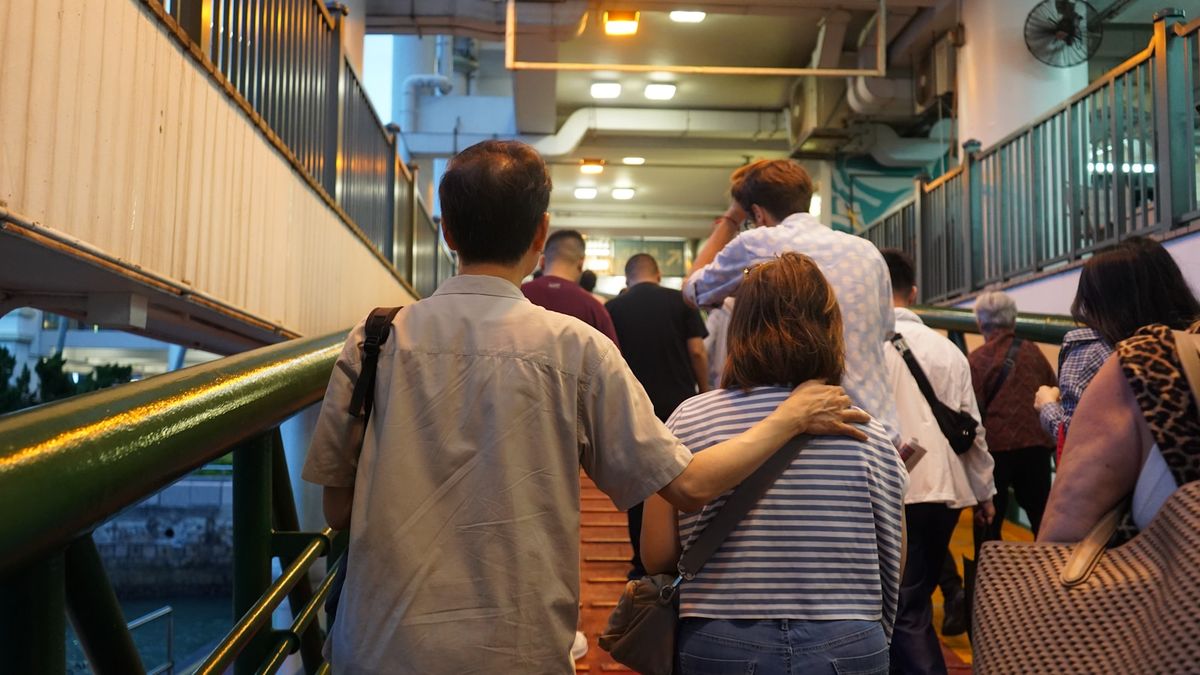 Foot passengers walking up a ramp to board a ferry