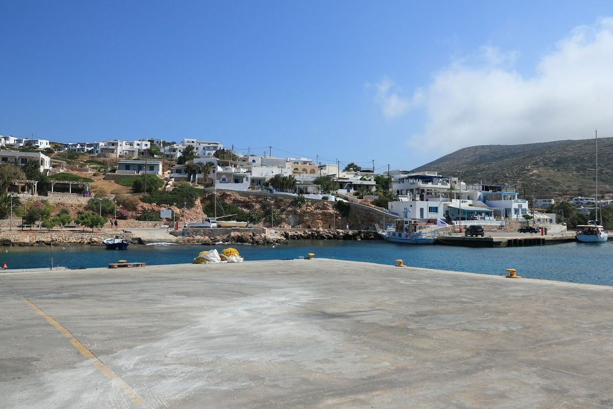 Greek island harbor with white buildings and blue water
