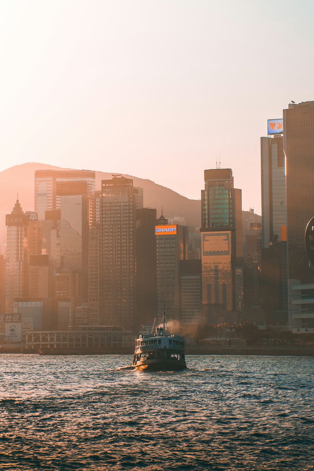 Ferry boat crossing Victoria Harbour with Hong Kong skyline