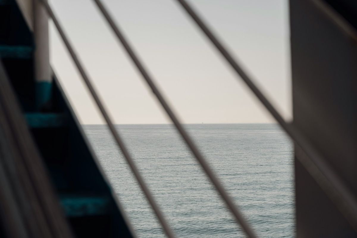 Calm ocean horizon seen through a ferry railing