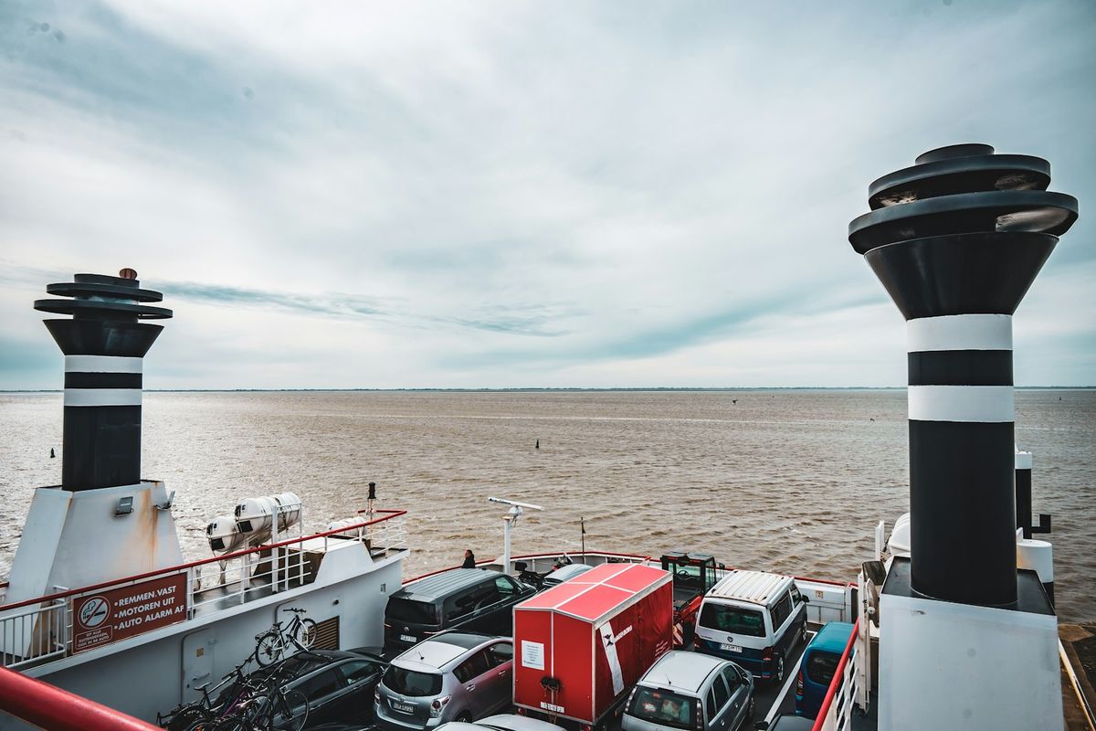 Cars parked on the deck of a ferry with funnels visible