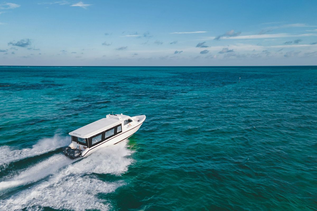 White speed ferry boat racing across blue tropical sea