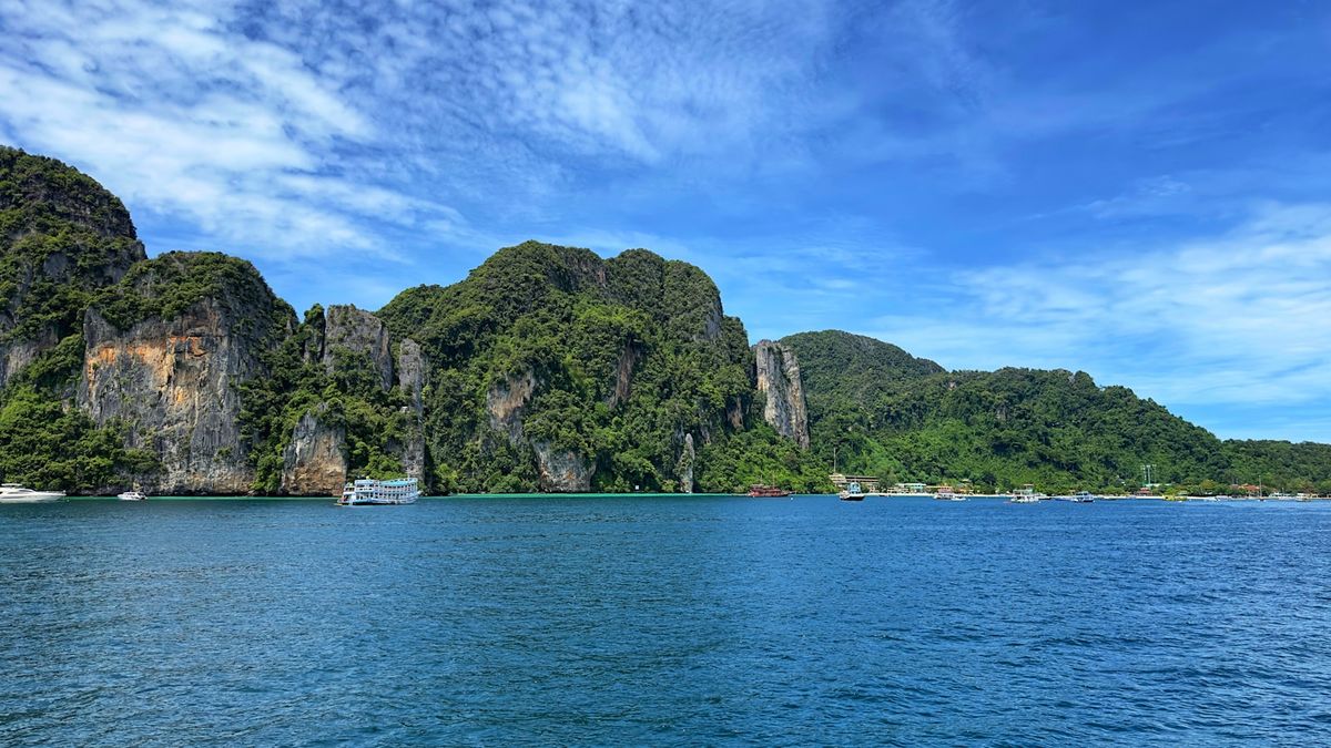 Rocky limestone cliffs with boats in Krabi waters