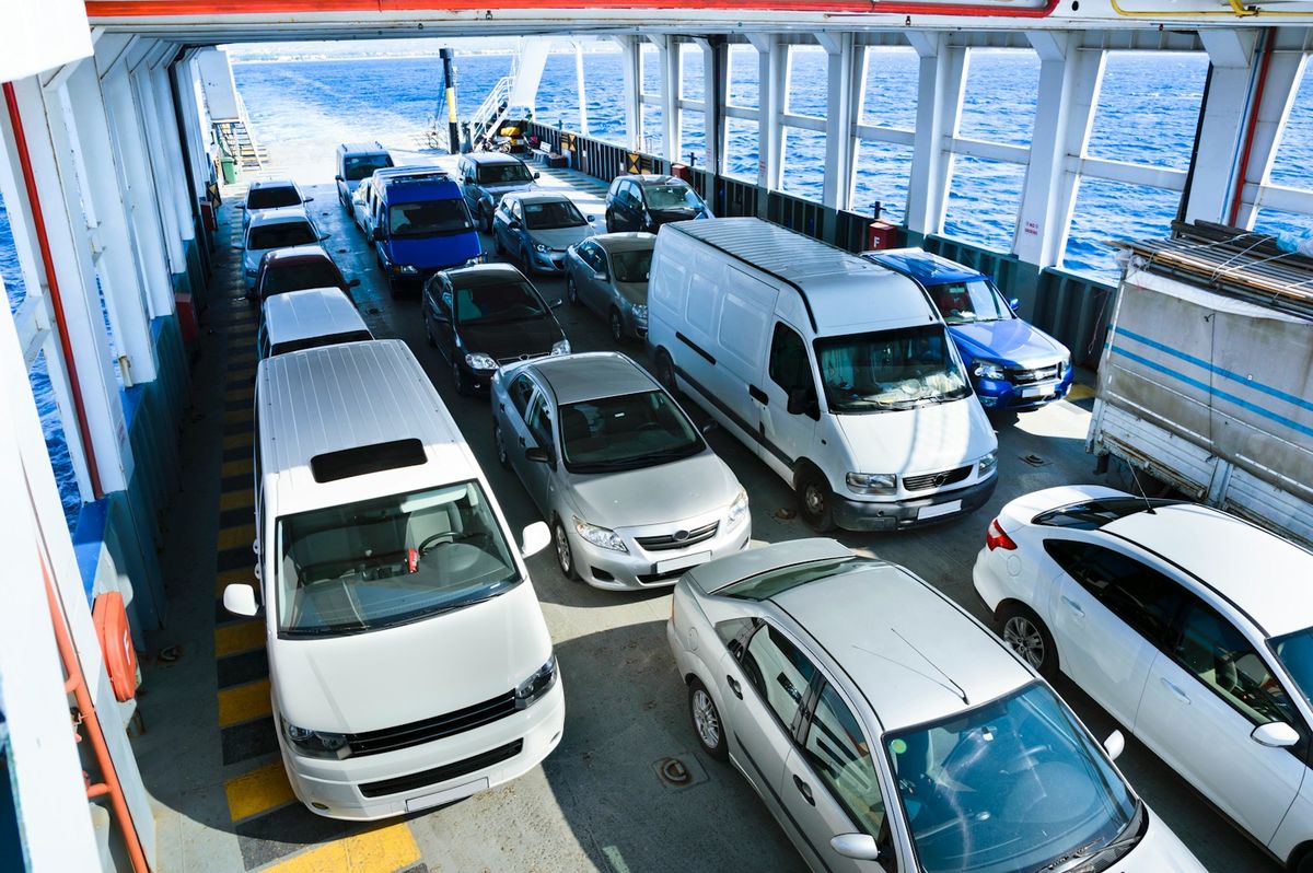 Vehicles lined up on a ferry car deck crossing the sea
