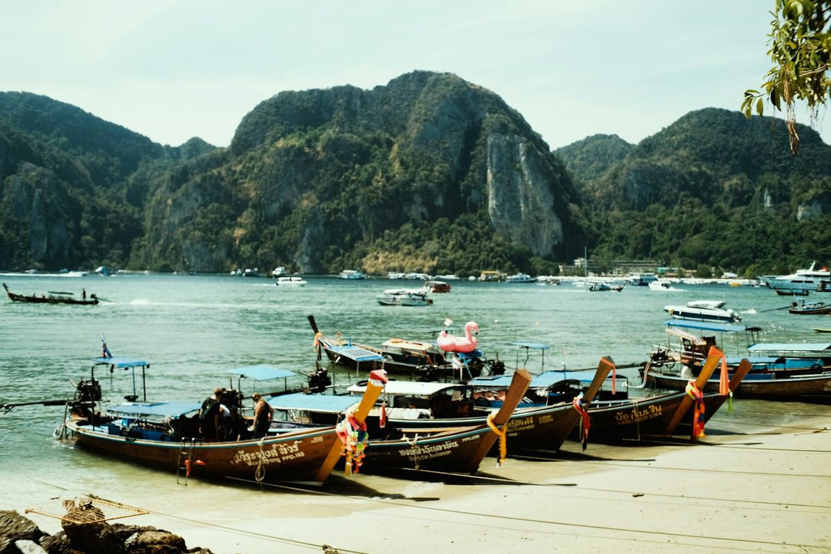 Longtail boats lined on Tonsai beach with Phi Phi limestone mountains