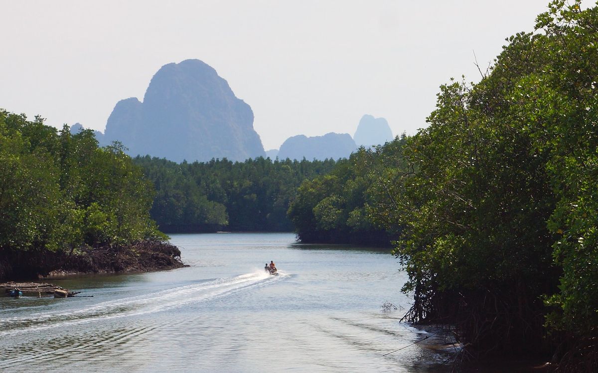 Boat navigating through Phang Nga Bay limestone karst islands