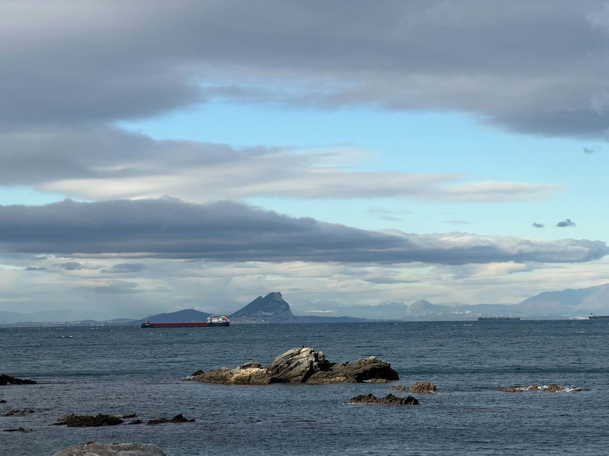 Ship sailing past a rocky outcrop in the Strait of Gibraltar