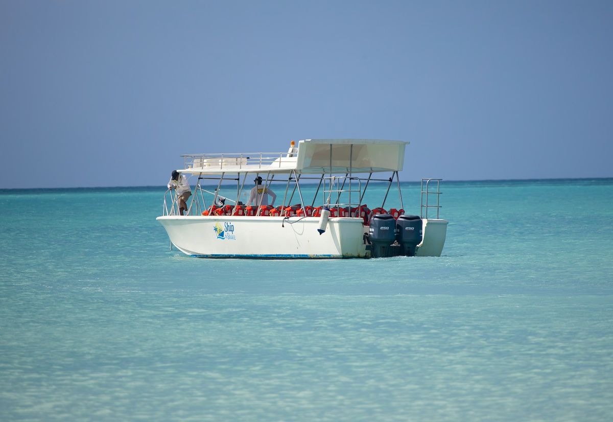 White dive boat with snorkellers in clear turquoise sea