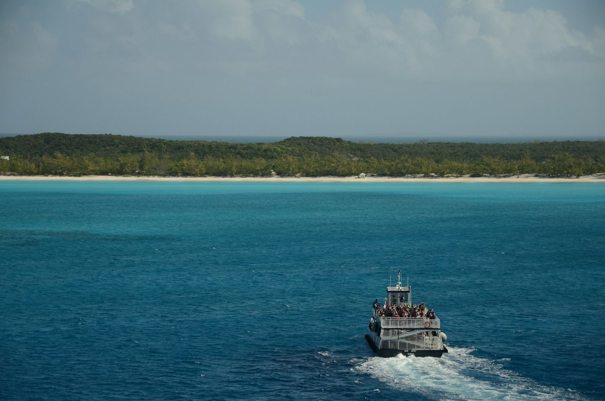 Ferry boat crossing turquoise ocean to tropical island