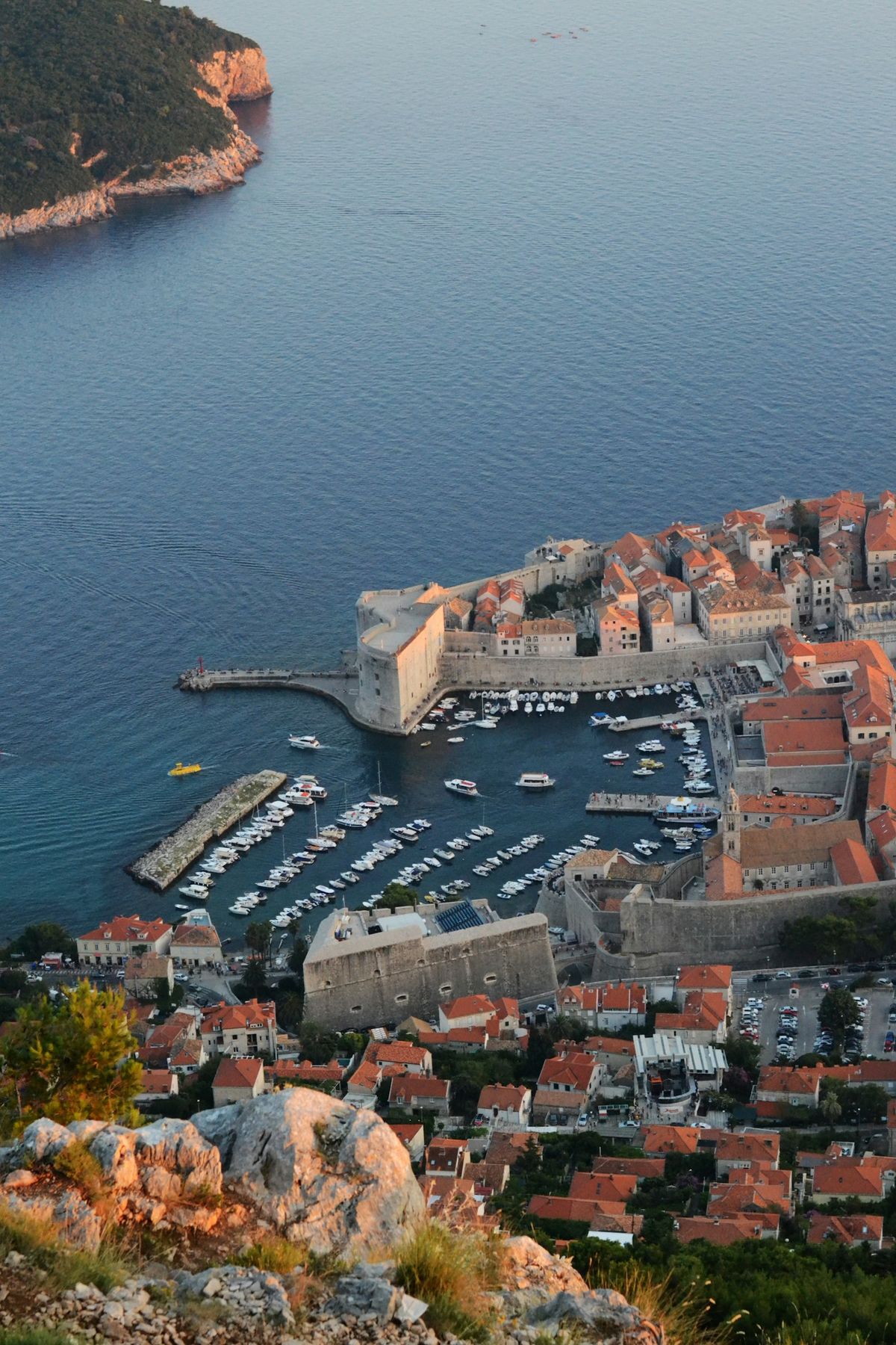 Aerial view of orange-roofed coastal town beside the Adriatic Sea in Croatia