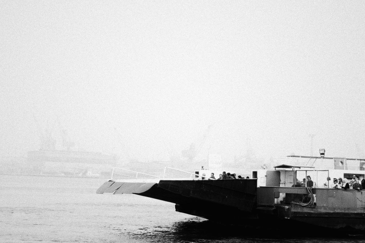 Two ferries docked at port on a foggy, overcast day
