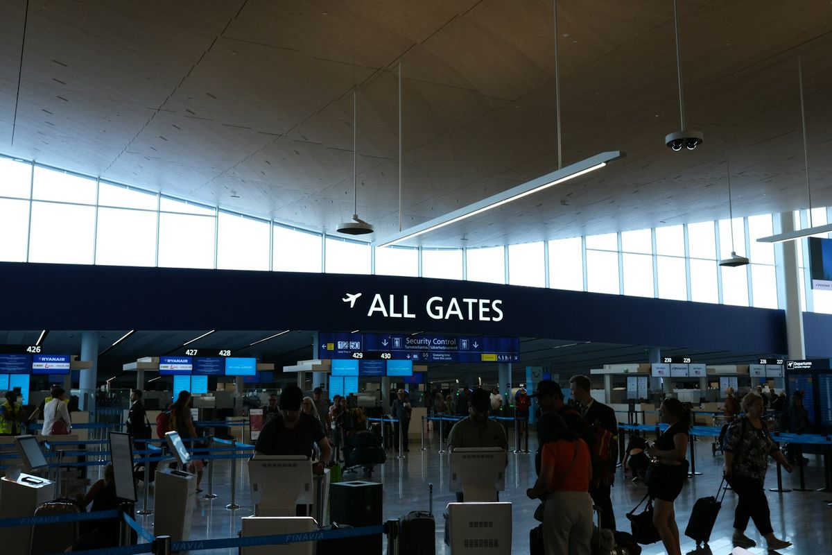 Passengers walking through an airport terminal corridor