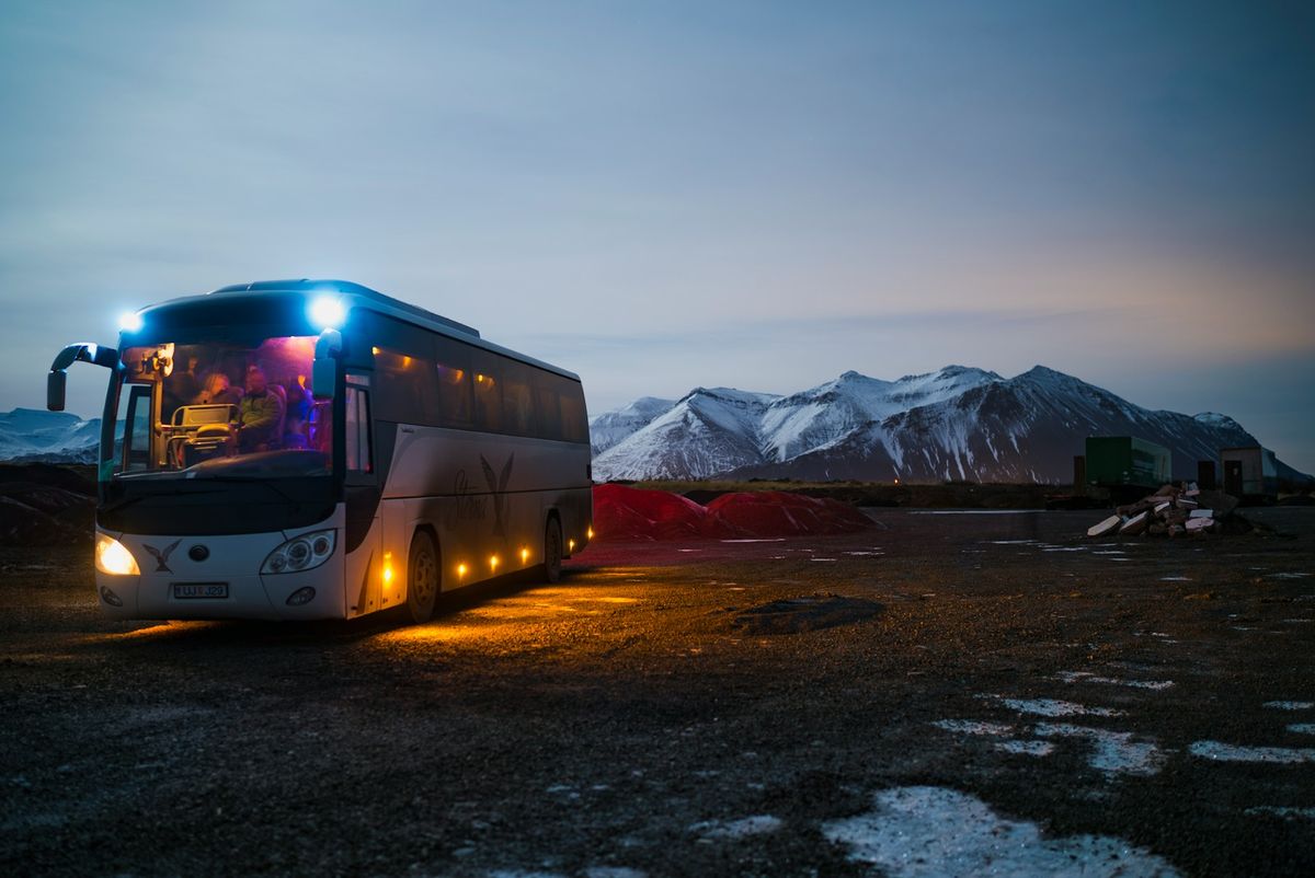 White and black long-distance coach bus near mountains