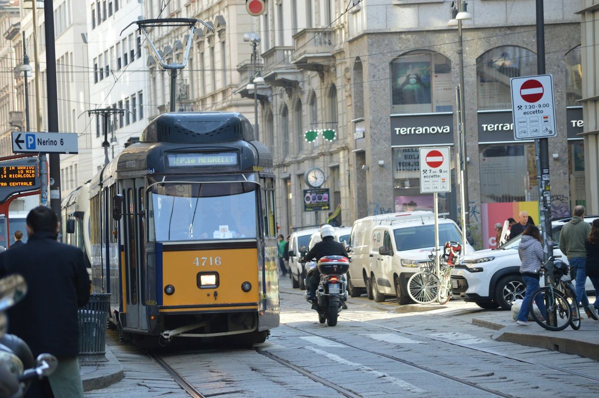 Tram on a city street with pedestrians in Europe
