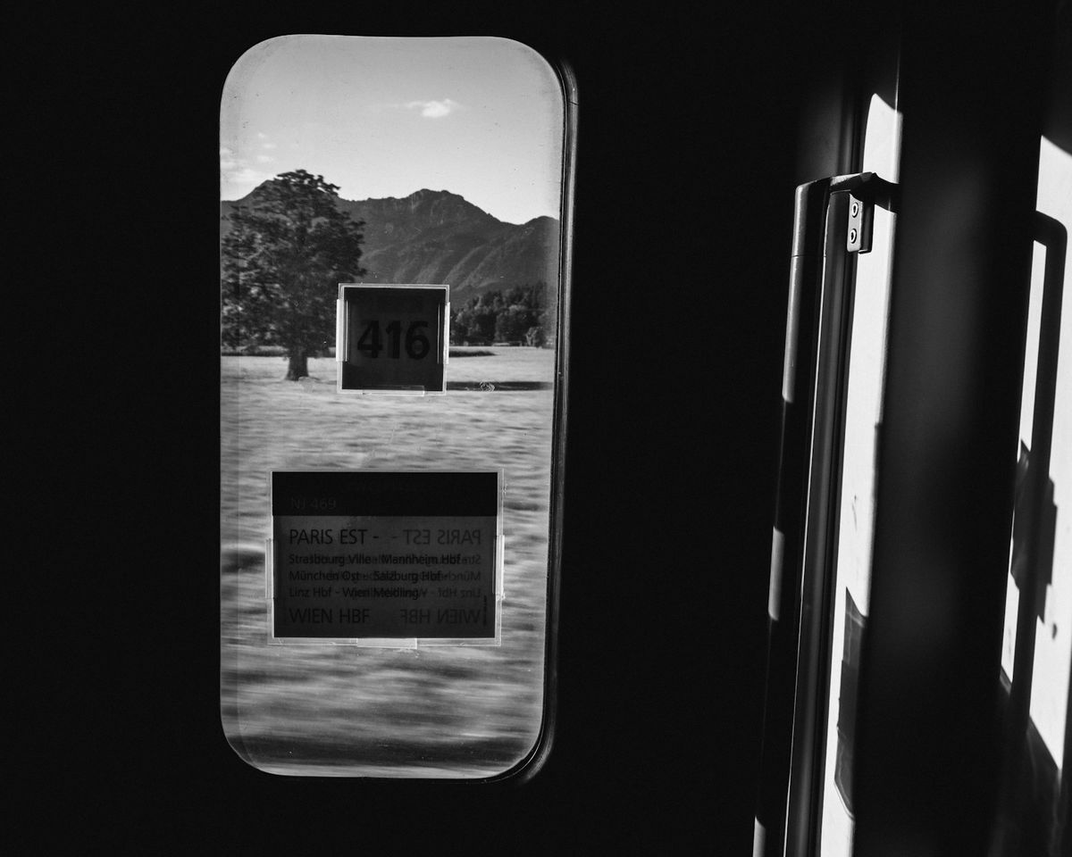View through a train window of a mountainous European landscape