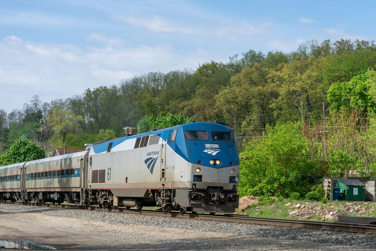 Blue and white passenger train traveling down railway tracks