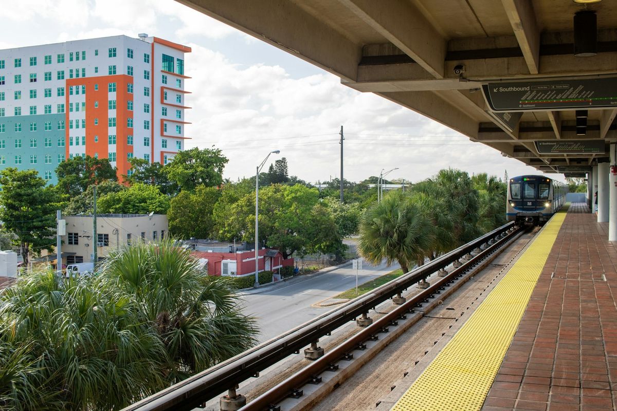 Modern elevated train next to a high-rise building