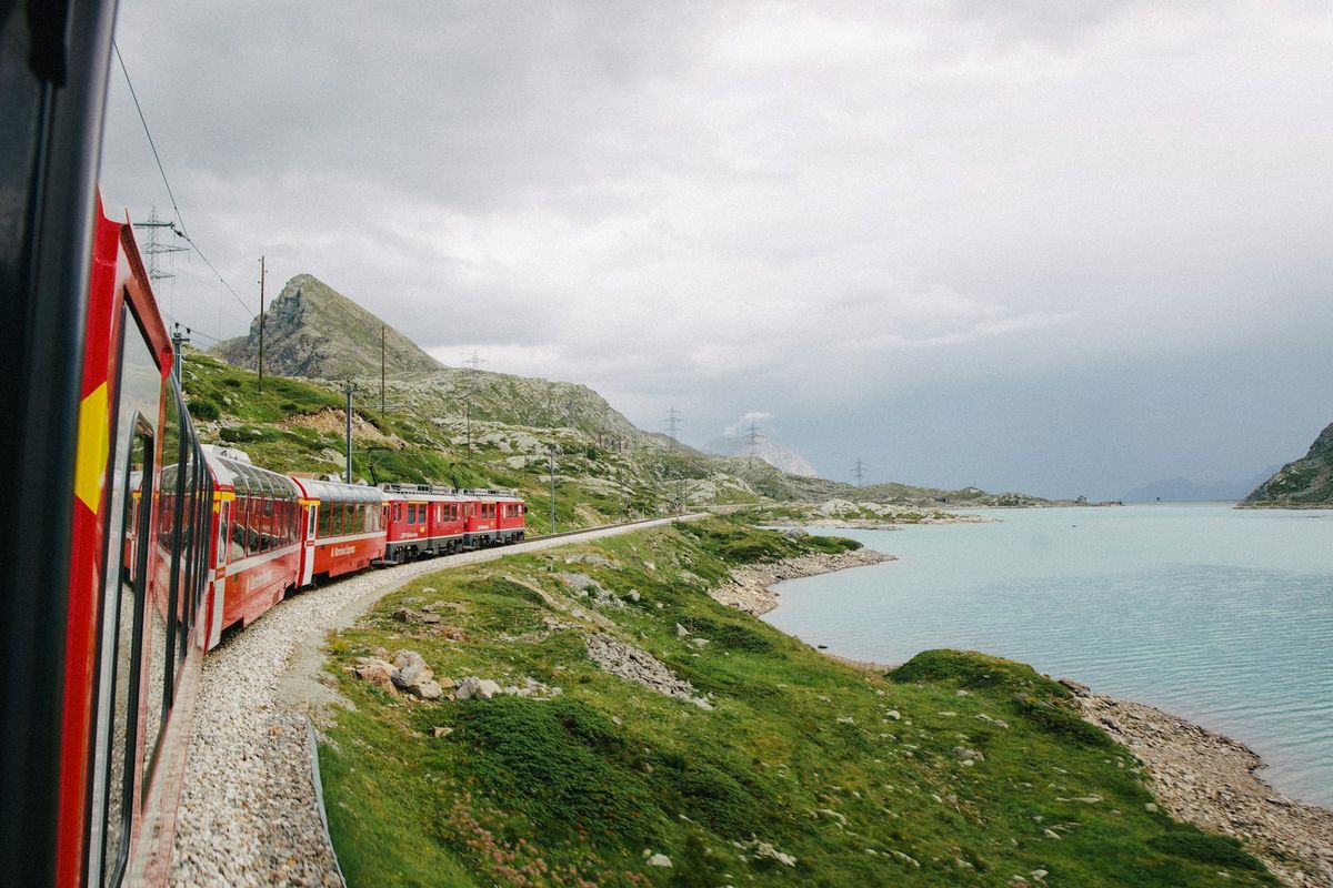 Glacier Express red train crossing a viaduct in the Swiss Alps