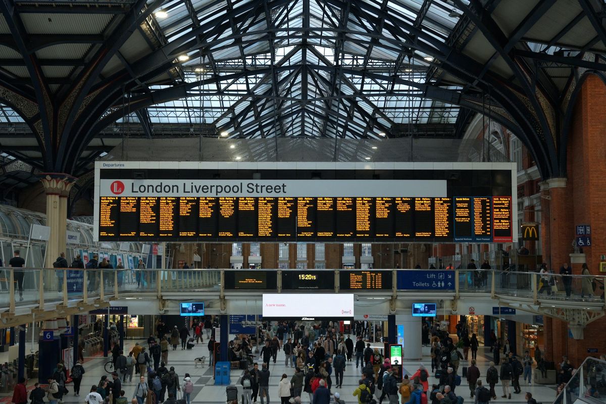 Busy train station concourse with departure board