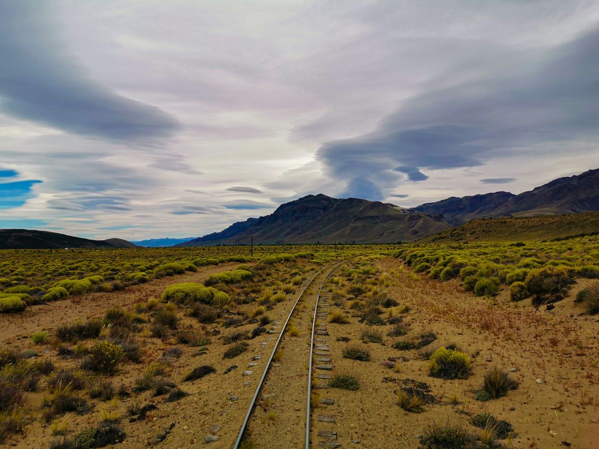 Railway tracks stretching through a desert landscape