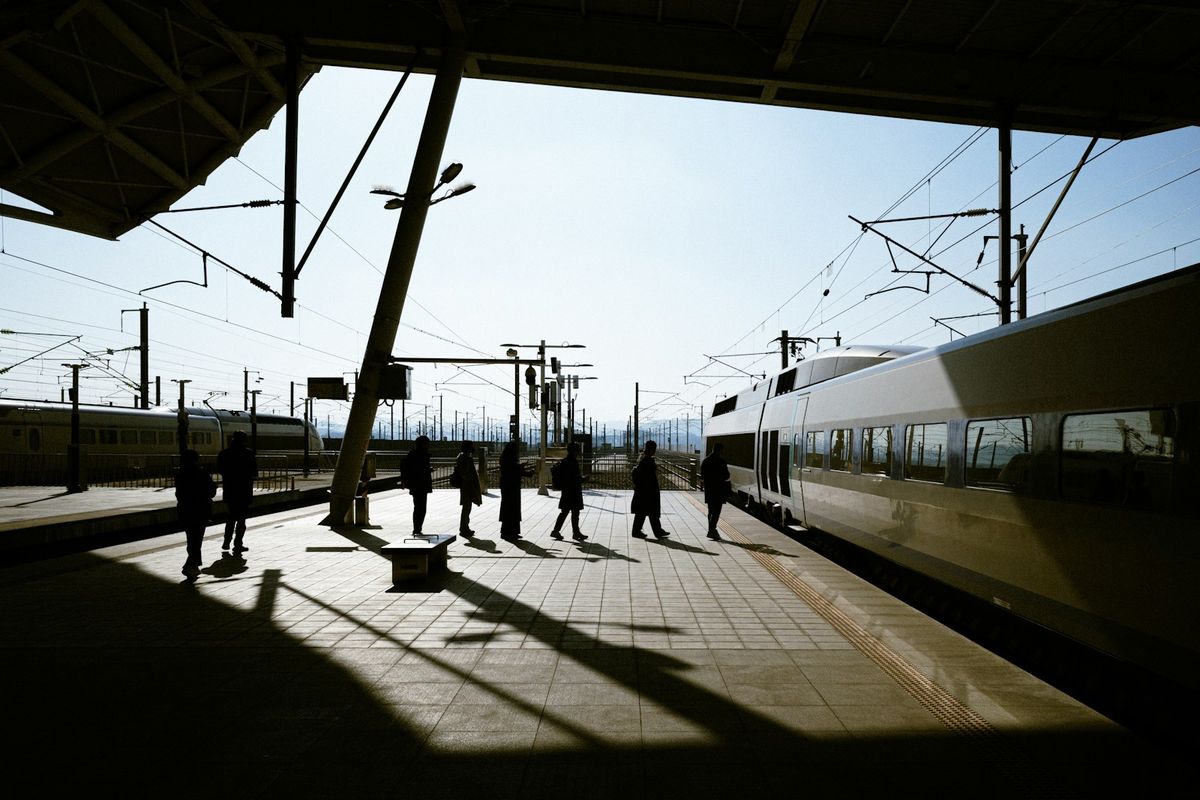 Passengers standing next to a train at a Korean station