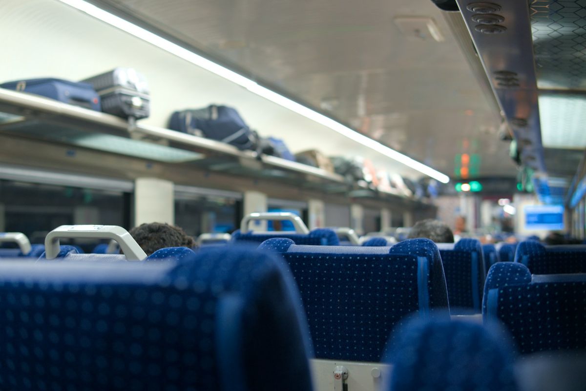 Luggage stored on overhead racks inside a train
